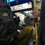 Bus riders on their phones