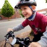 Child rides bike to school with big grin on his face!