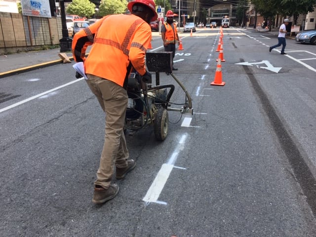 Crews add new paint markings to a street in Seattle