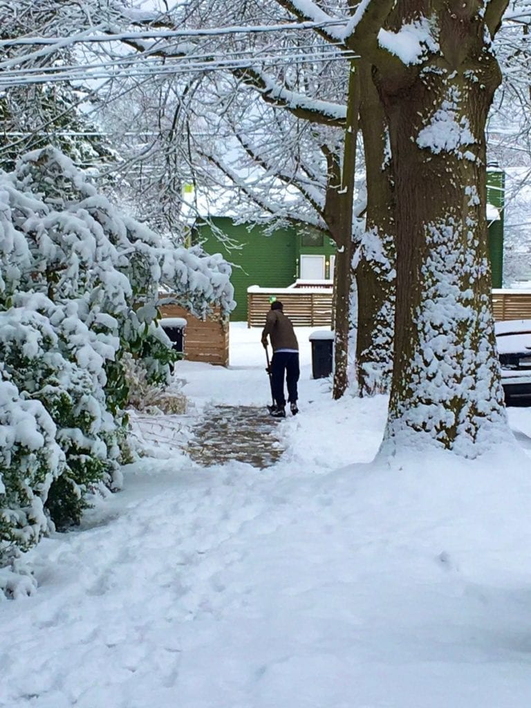 Man shoveling snow from sidewalk