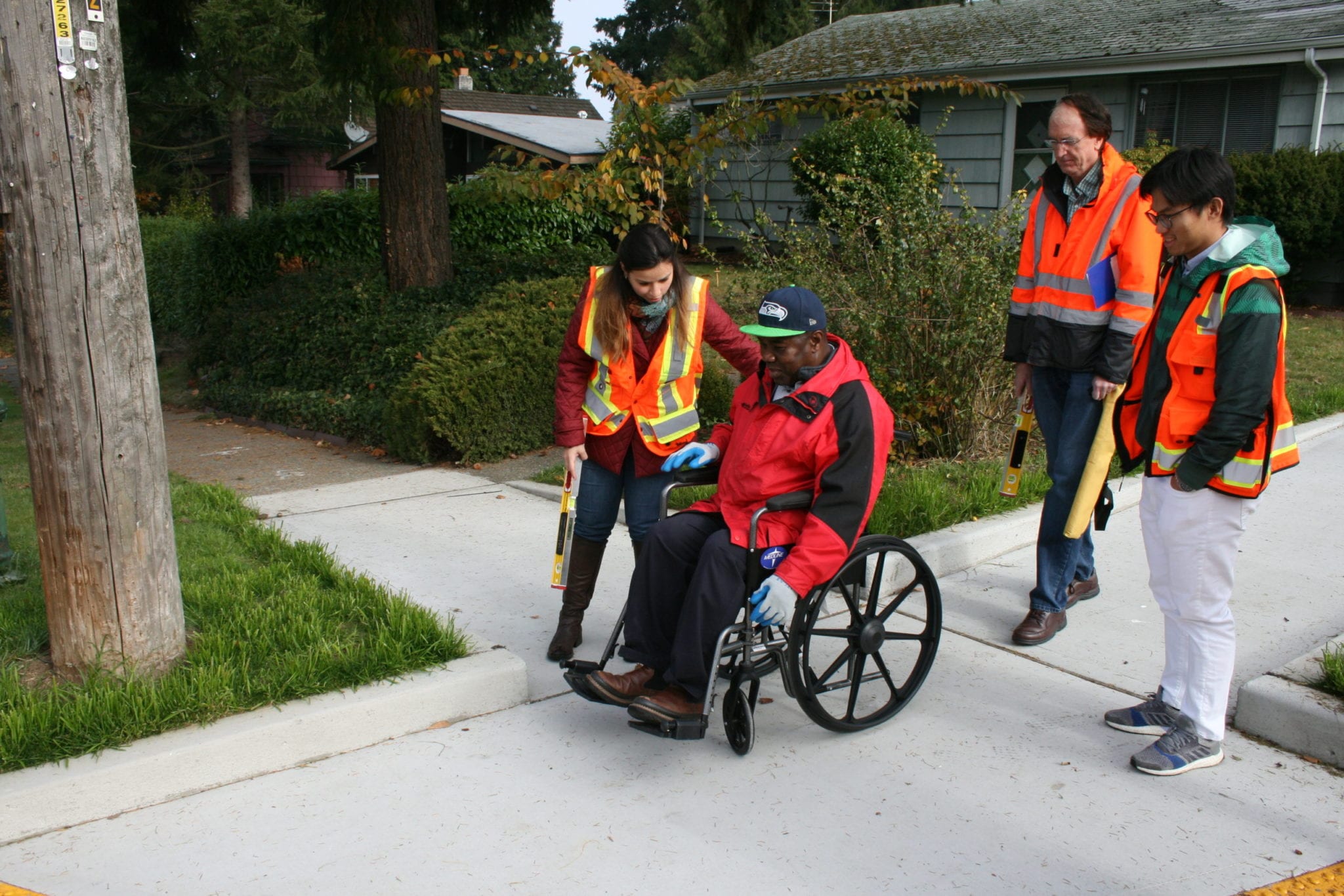 Road engineers using a wheelchair on the sidewalk.