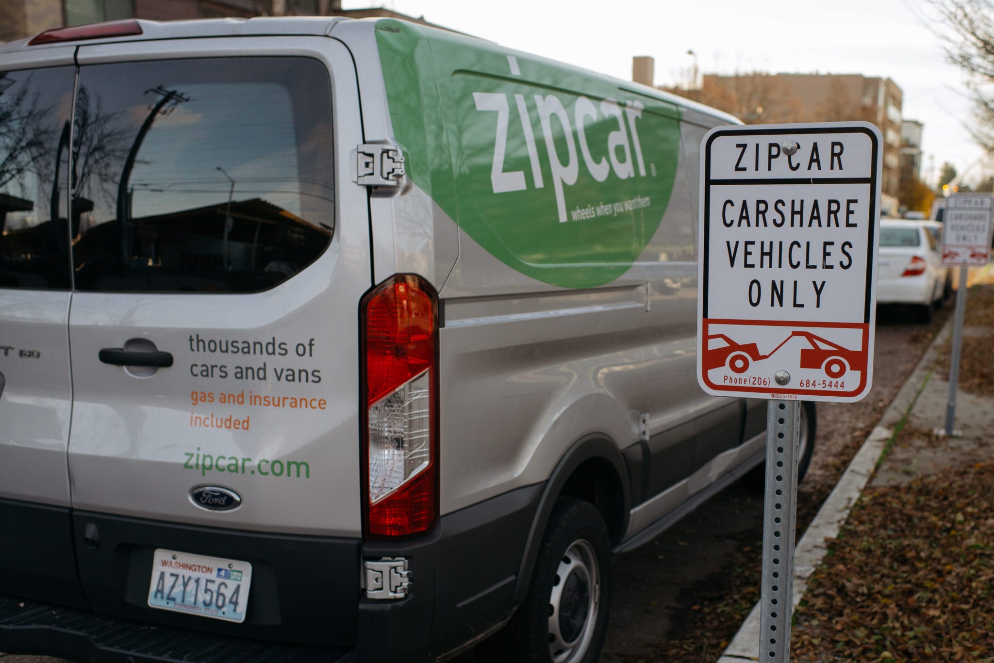A Zipcar van parked near a car share vehicle only sign.