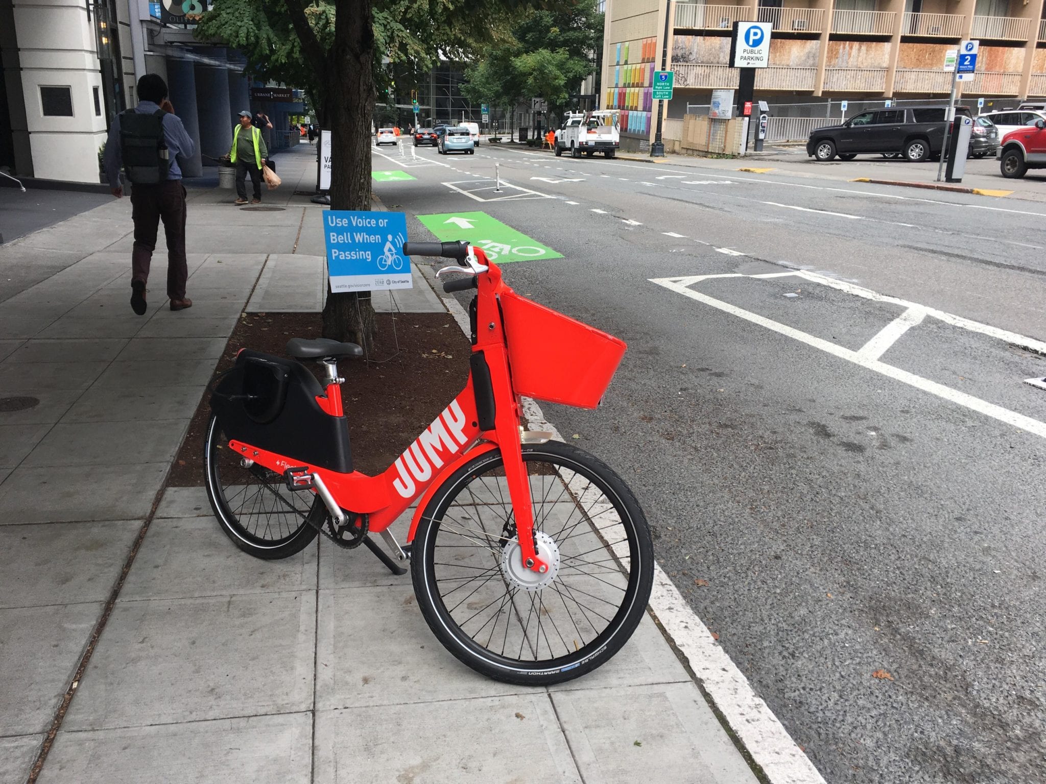 A JUMP bike parked in Downtown Seattle with people walking by.