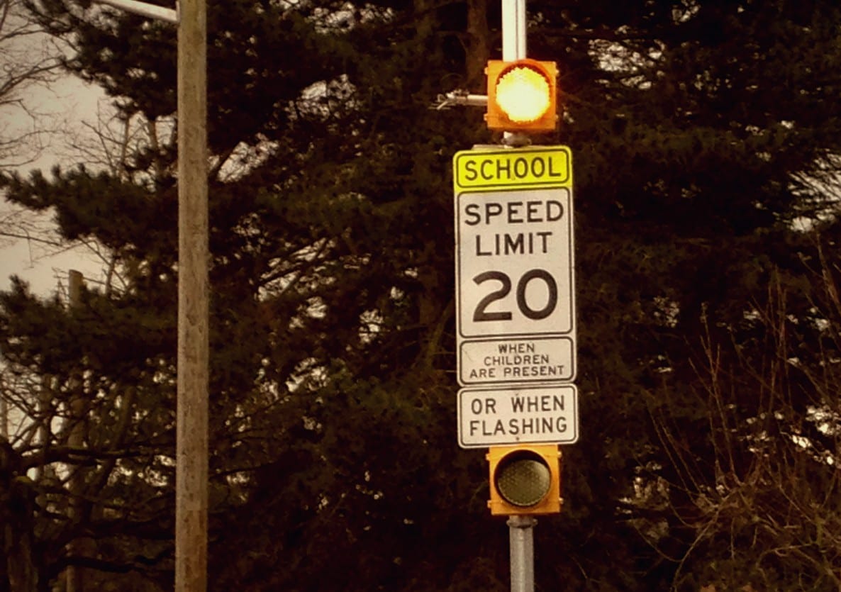 A flashing sign in a school zone, with a speed limit of 20.
