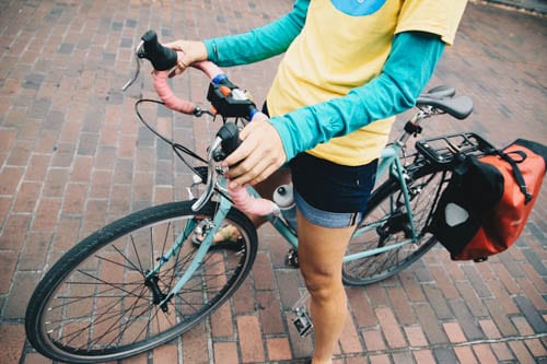 Person in yellow and teal shirt riding a bike. 