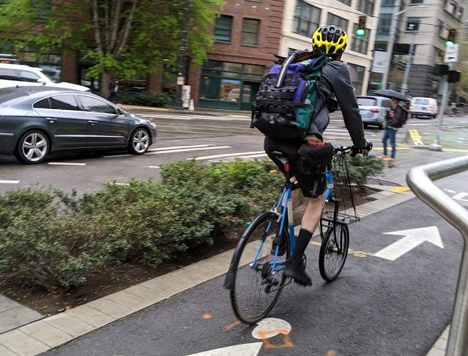 Person riding bike on 7th Ave protected bike lane