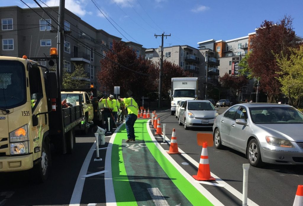 crew painting protected bike lane on Avalon Way