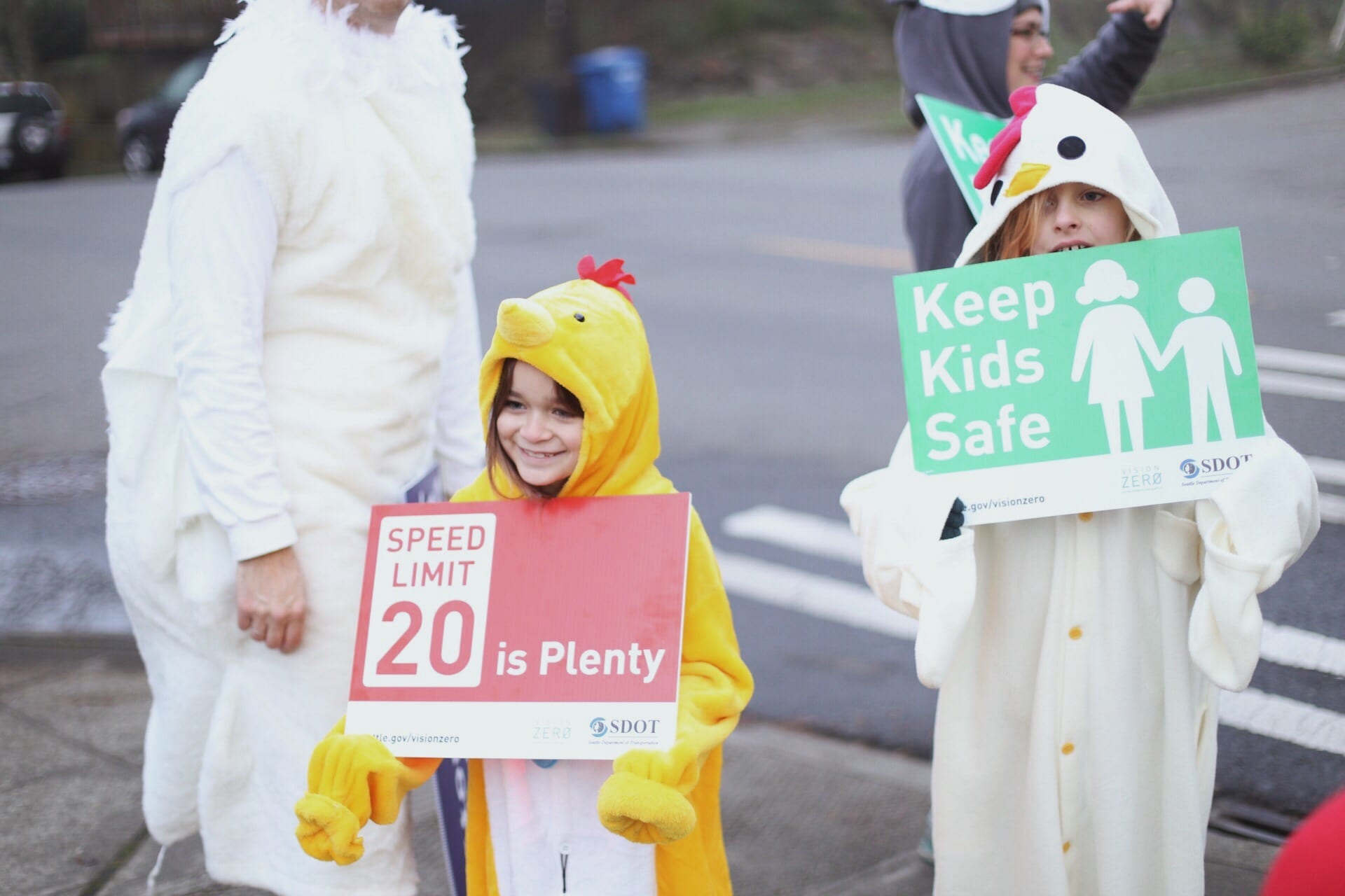Elementary school parents and kids holding Vision Zero signs in 2017 encouraging people to slow down on Seattle streets. 