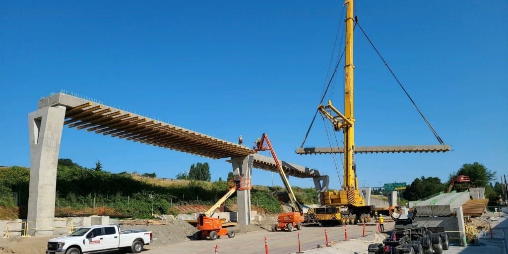 A crane holding up part of the future Northgate Pedestrian & Bike Bridge.