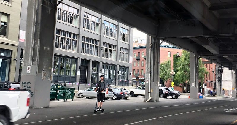 Person on a scooter riding under the Alaskan Way Viaduct.