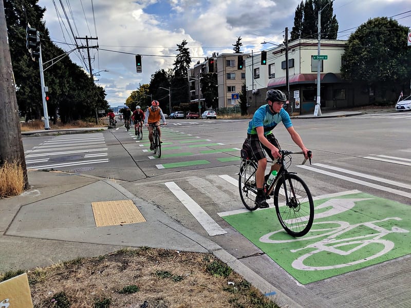 Four people are seen biking in a bike lane in Seattle.