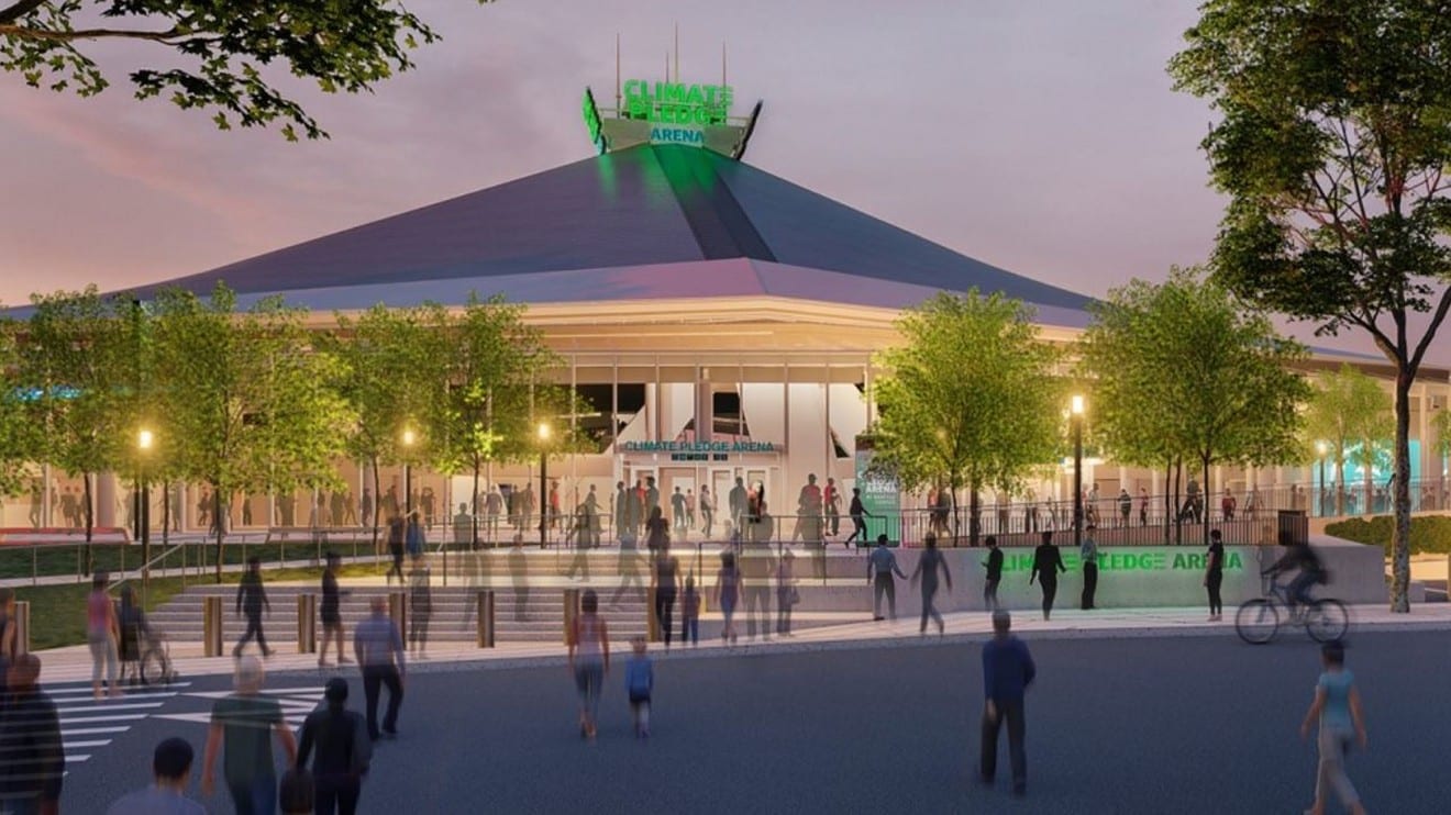 A rendering of the new Climate Pledge Arena with people walking around it at dusk.