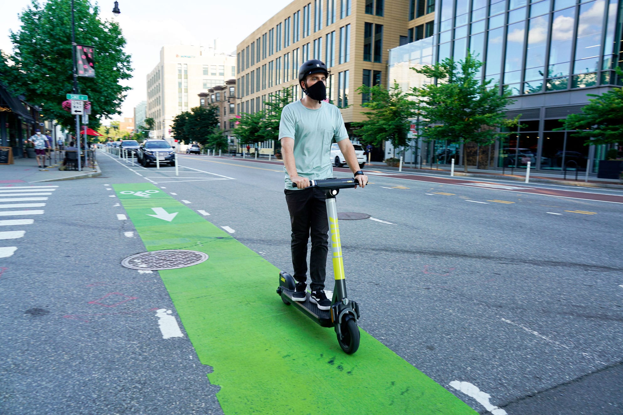 Person riding LINK scooter on a bike lane.
