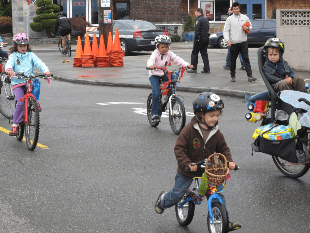 Children biking on a street together.