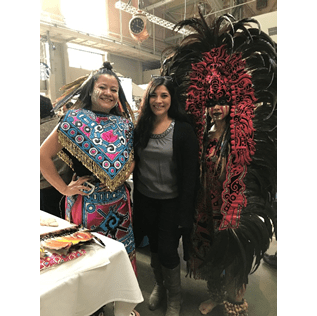 Sonia with dancers from Tloke Nahuake who performed at the “Dia de Muertos Festival Seattle”  in October 2018. Dancers are in colorful costumes.