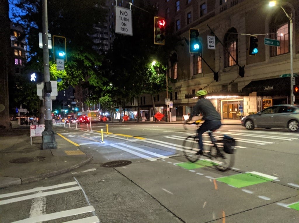 Person riding at night on the 4th Ave protected bike lane.