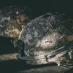 Two military helmets resting on a table/surface.