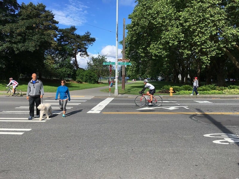 People walking and biking at intersection of E Green Lake Way N/E Green Lake Dr N & N 71st St in 2017.