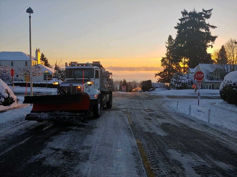 A snowplow is shown on an icy road in Seattle.