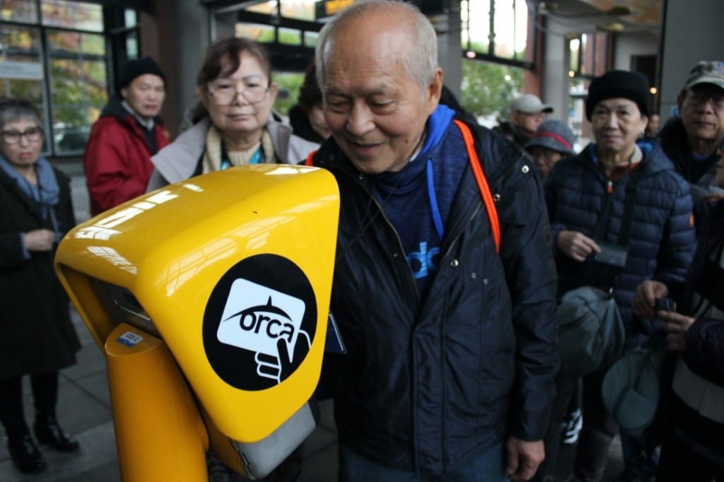 Elderly man tapping an ORCA card at a Link Light Rail station in pre-pandemic days.