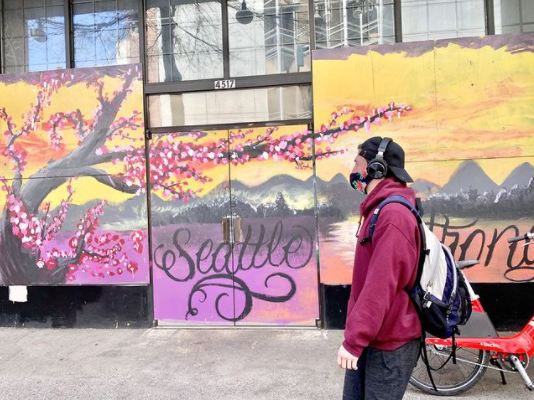 Person walking past a colorful mural that says 