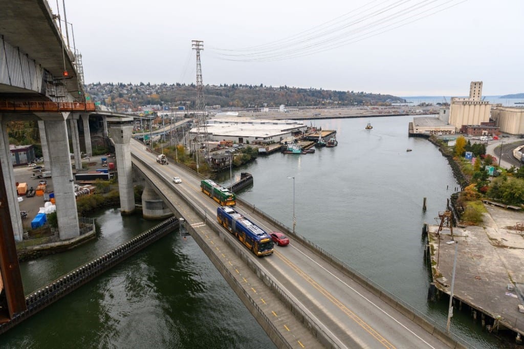 The West Seattle Low Bridge viewed from above; the photo was taken from the work platforms on the West Seattle High Rise Bridge. Two buses, two small cars, and one truck are shown crossing the bridge.
