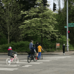 Family biking and walking across NE 130th St.