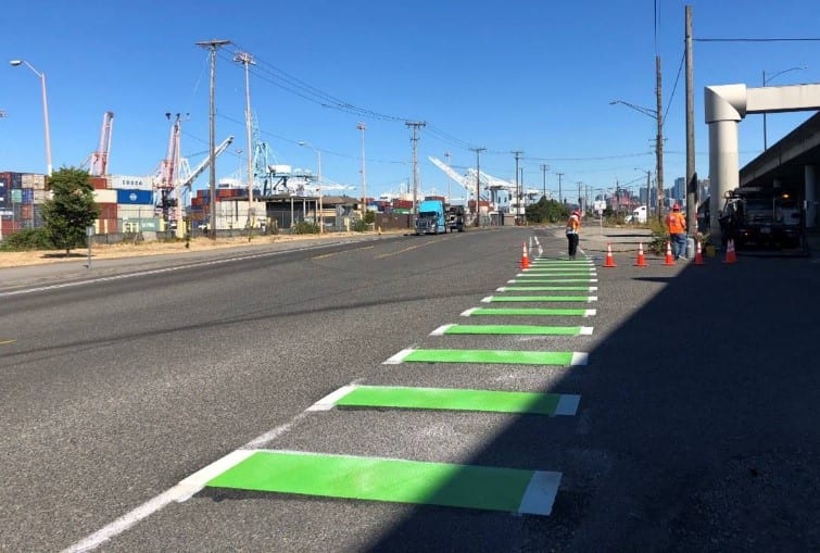 The existing bike lane on East Marginal Way S was enhanced with restriping and refreshing the posts that separate people driving from people biking. Photo Credit: SDOT. 