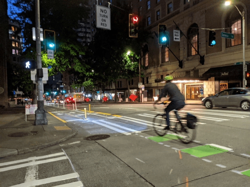 Person using the new 4th Ave protected bike lane on a fall evening. Photo Credit: Dongho Chang. 
