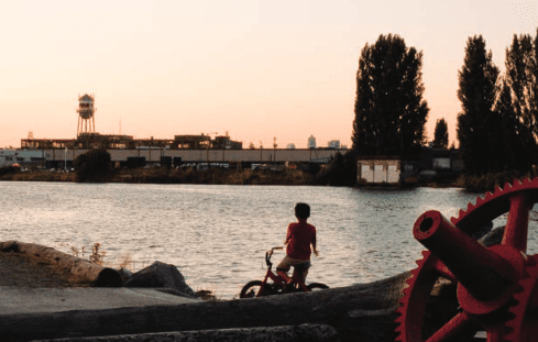 Child on bike looking at the Duwamish River