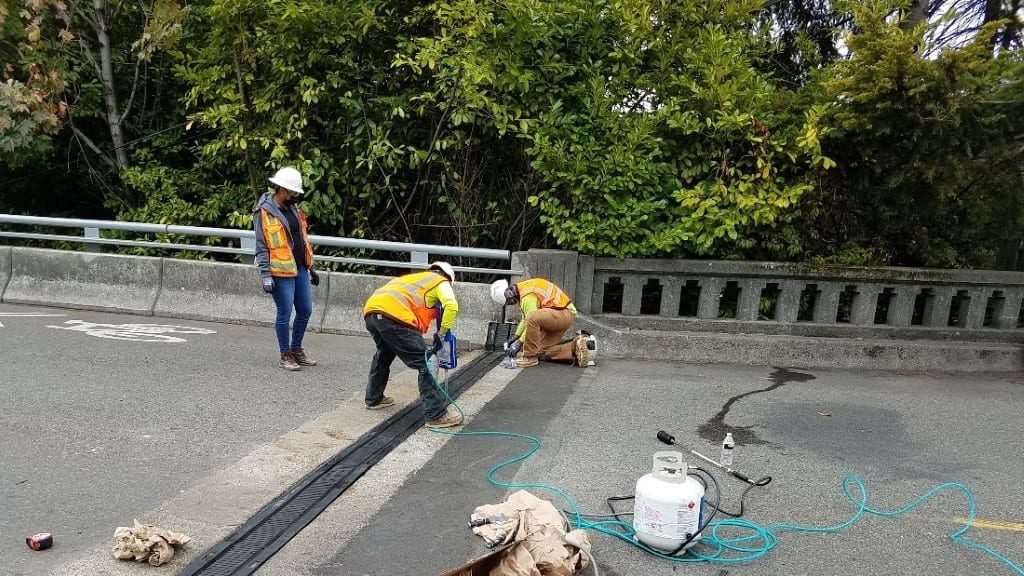 crew members install a new expansion joint at the east end of the bridge to help with the bridge movement during an earthquake. 