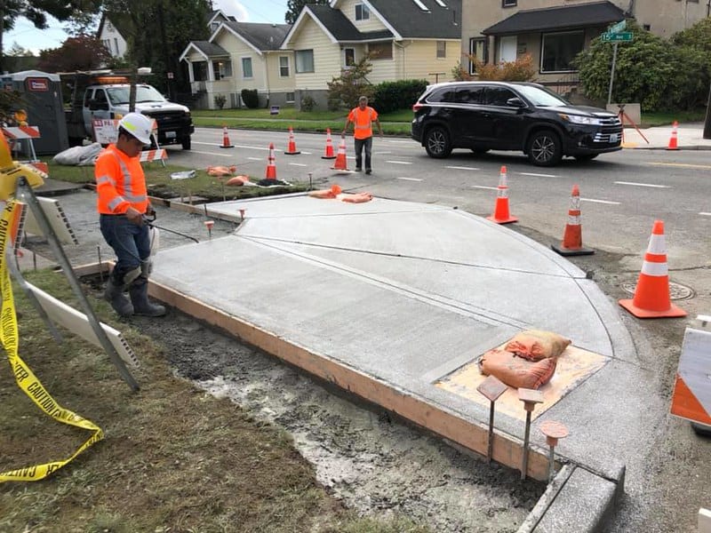 Part of the work includes constructing curb ramps. Here, curb ramps are being constructed back in early 2020. Photo Credit: SDOT Flickr.