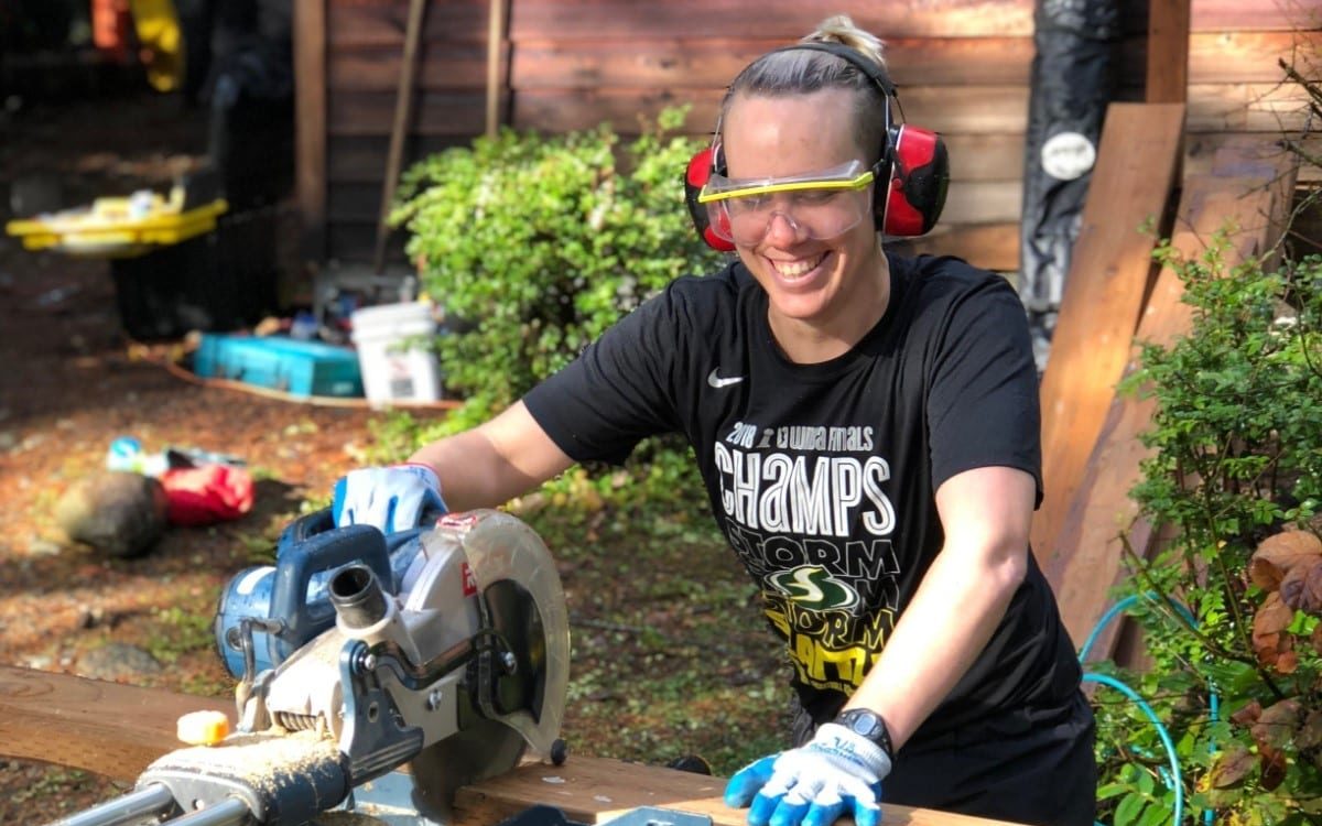 Becky using a chop saw cutting a blank of wood