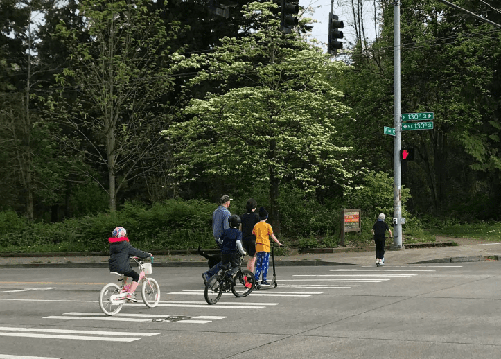 Family biking and walking across NE 130th St.