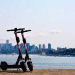 two spin scooters pictured with seattle skyline in background