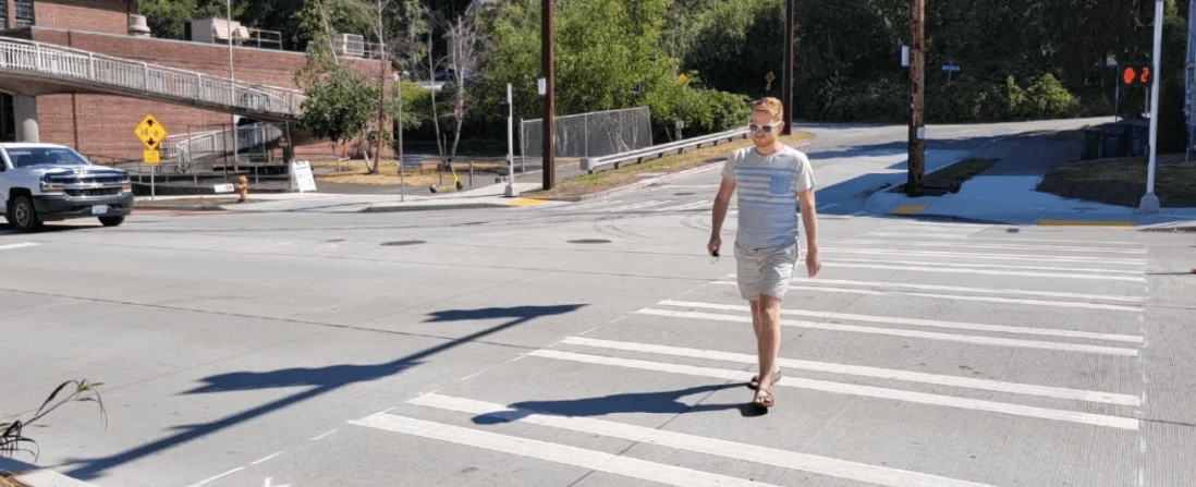 A person uses the new signal to cross the street. 
