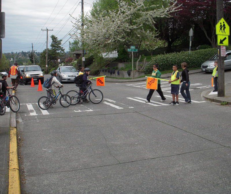 Crossing the street to school with pedestrian crossing flags. Photo Credit: SDOT.