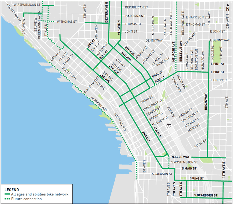 A map of the City of Seattle's City Center Bike Network routes, including routes that are currently open and future planned routes. Bike routes are shown with green solid or dotted lines, focused on downtown Seattle and surrounding neighborhoods. Elliott Bay is visible on the left side in blue representing water.