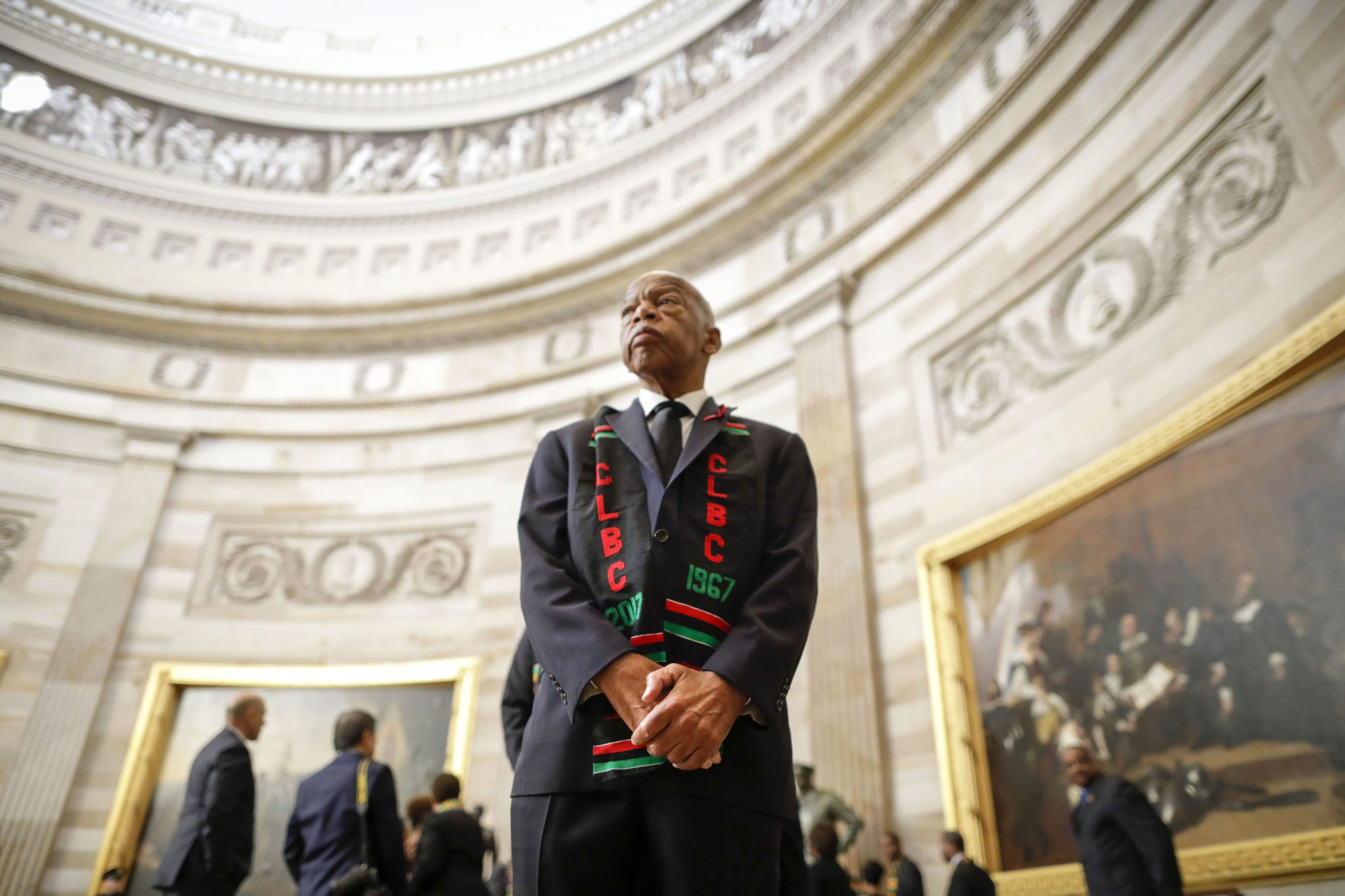 Photo of Congressman John Lewis standing tall at the U.S. Capitol in Washington, D.C. in 2019. Congressman John Lewis looks somber and thoughtful. Other elected officials are visible in the background, along with artwork in the U.S. Capitol building.