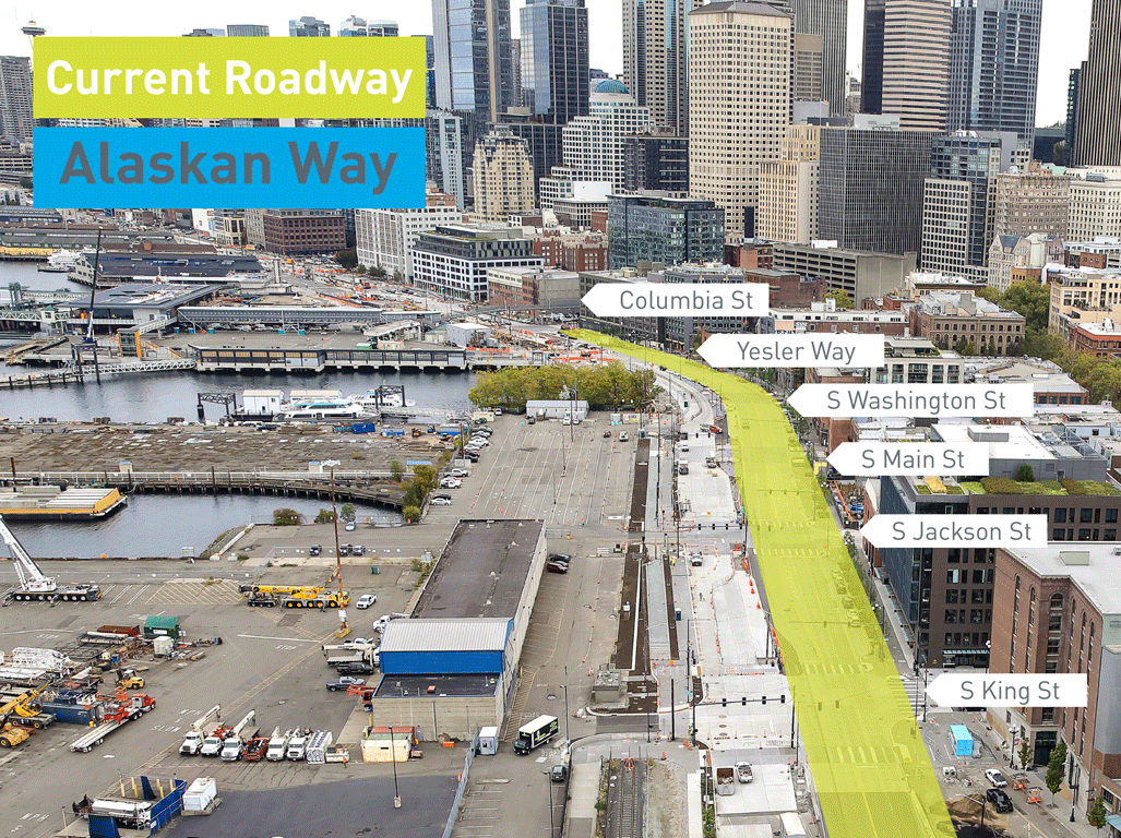 An animated image showing Alaskan Way in Seattle. The image showcases where traffic currently travels in a two-way configuration along Alaskan Way, in a yellow highlighted area. Once the traffic shift is complete, the yellow area will carry northbound traffic, while a new area highlighted in blue will carry southbound traffic. Large white arrow indicate the direction of current and future traffic, with buildings and waterfront areas visible, as well as buildings, in the rest of the image.