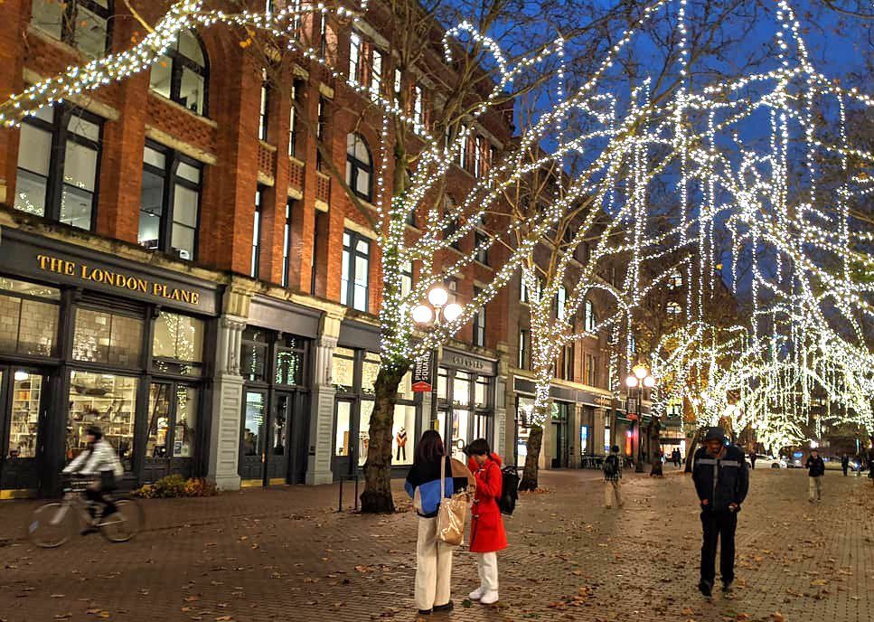 People walking along the holiday lights in Seattle’s Pioneer Square neighborhood.
