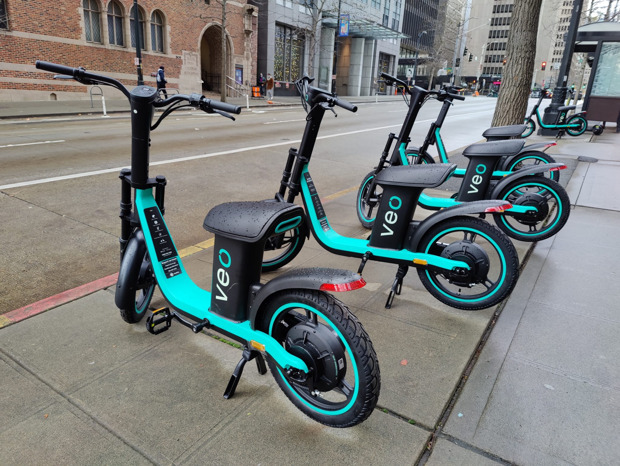 Veo e-bikes lined up on the sidewalk along 4th Ave in downtown Seattle.