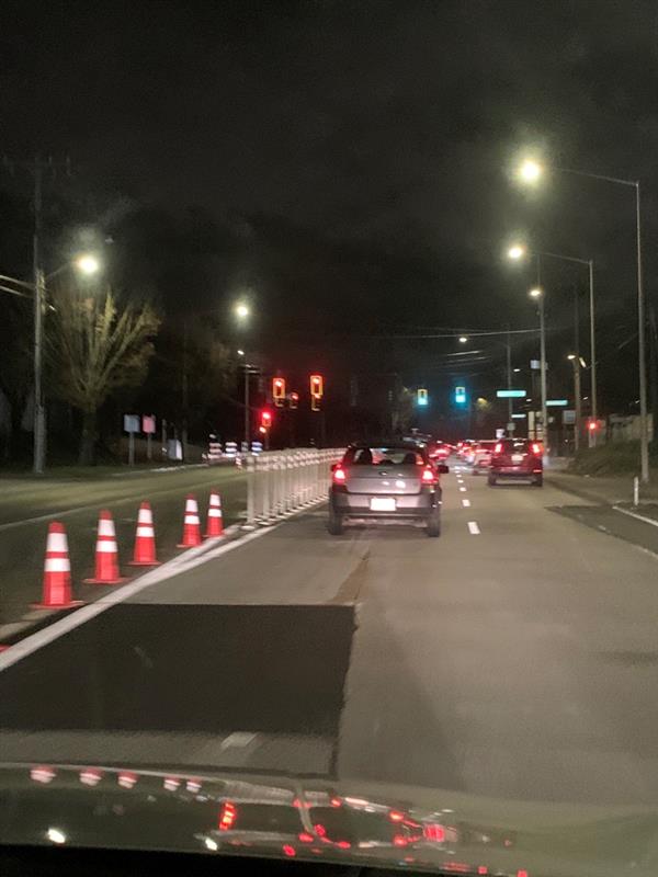 This photo shows high-visibility construction cones to mark detours for people driving, as well as for people walking, rolling, and biking in the area.