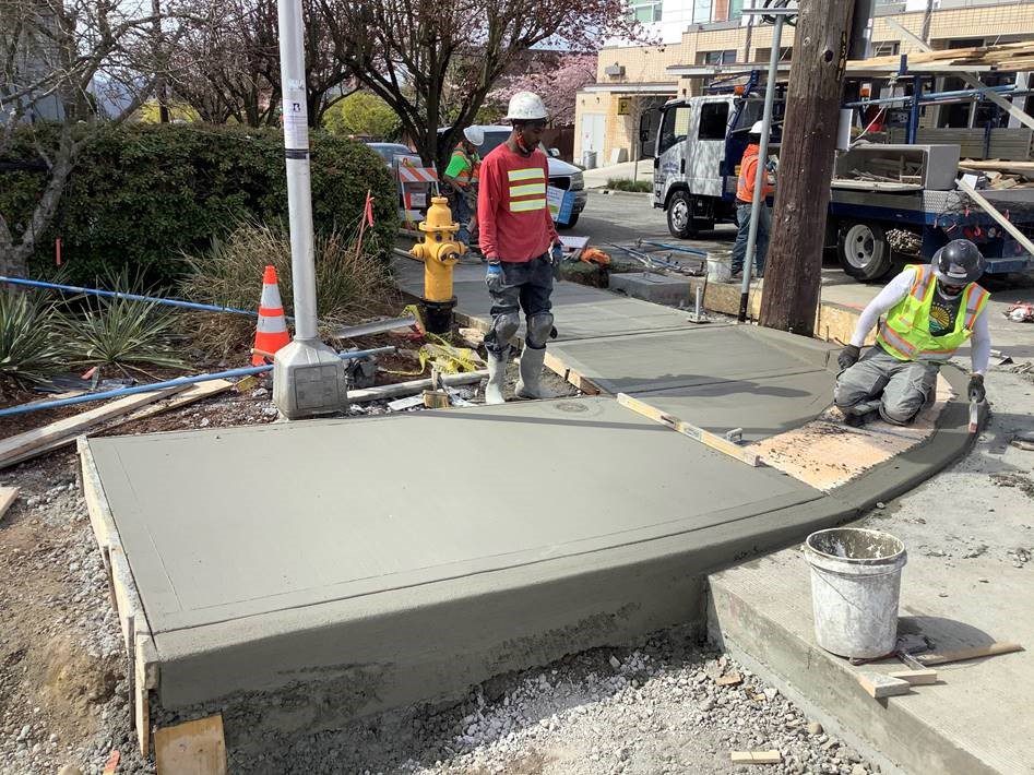 People work on installing a new sidewalk curb ramp near 15th Ave S in Seattle's Beacon Hill neighborhood.