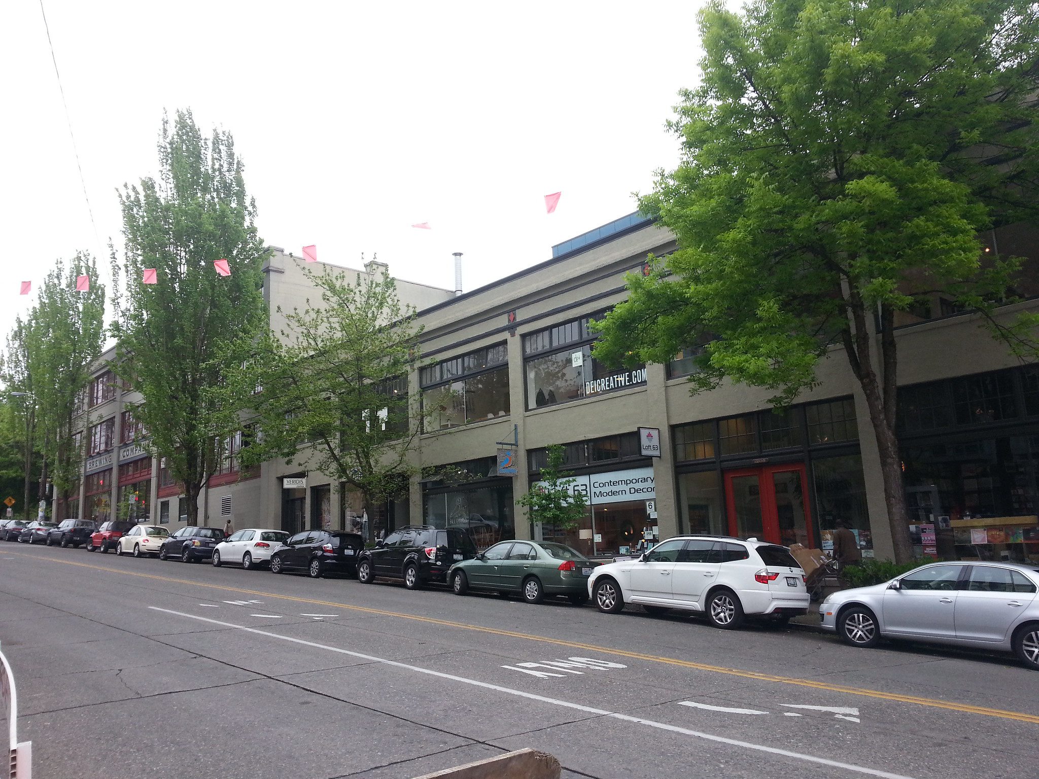 Photo of on-street paid parking in Seattle’s Capitol Hill neighborhood. Cars are lined up on the righthand curb spaces, parked in on-street paid parking spots near businesses in the area.
