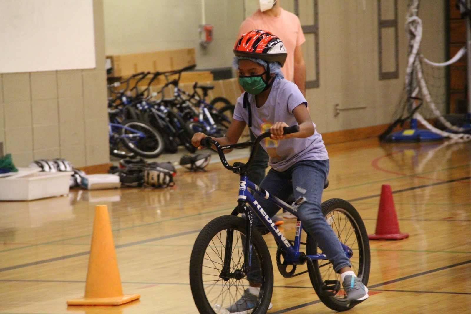 A student riding a bike in a gym