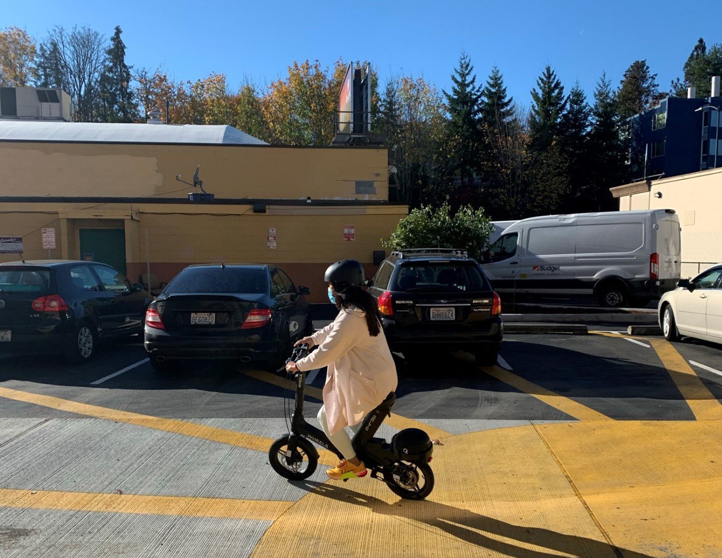 A woman practices riding a scooter at a scooter outreach event held in October 2021.
