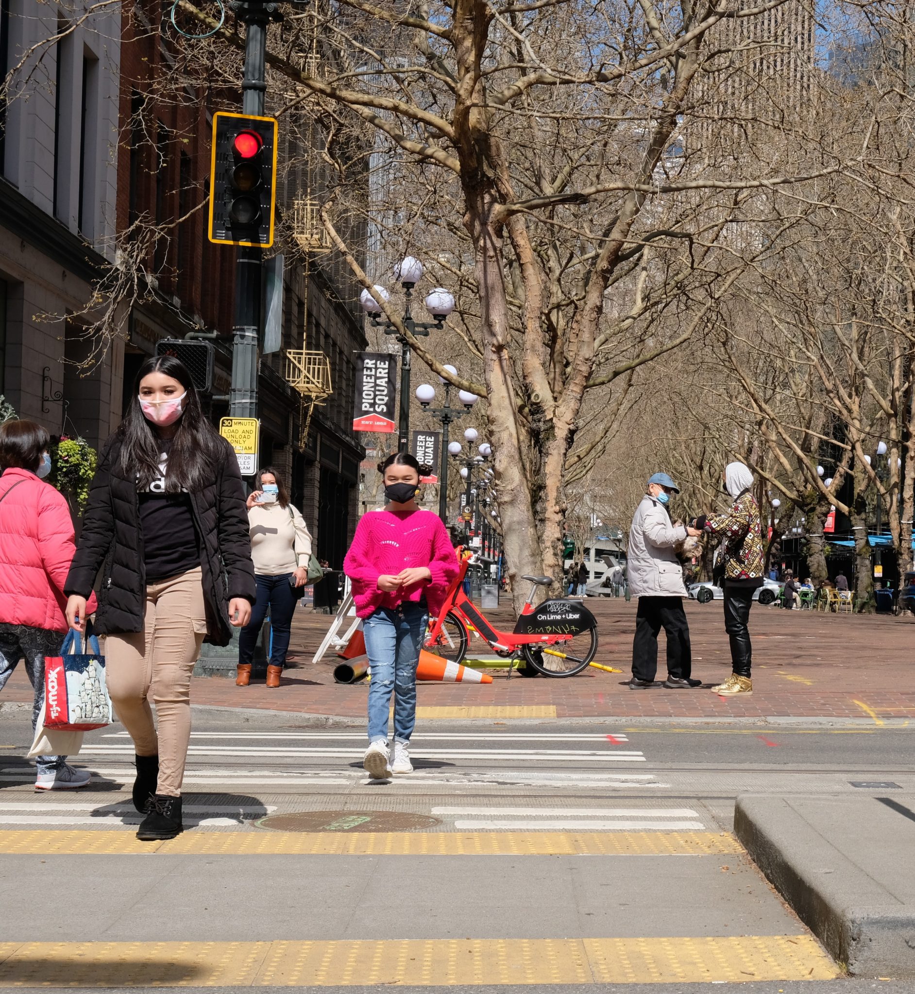 People walk across the street in Seattle’s Pioneer Square neighborhood.