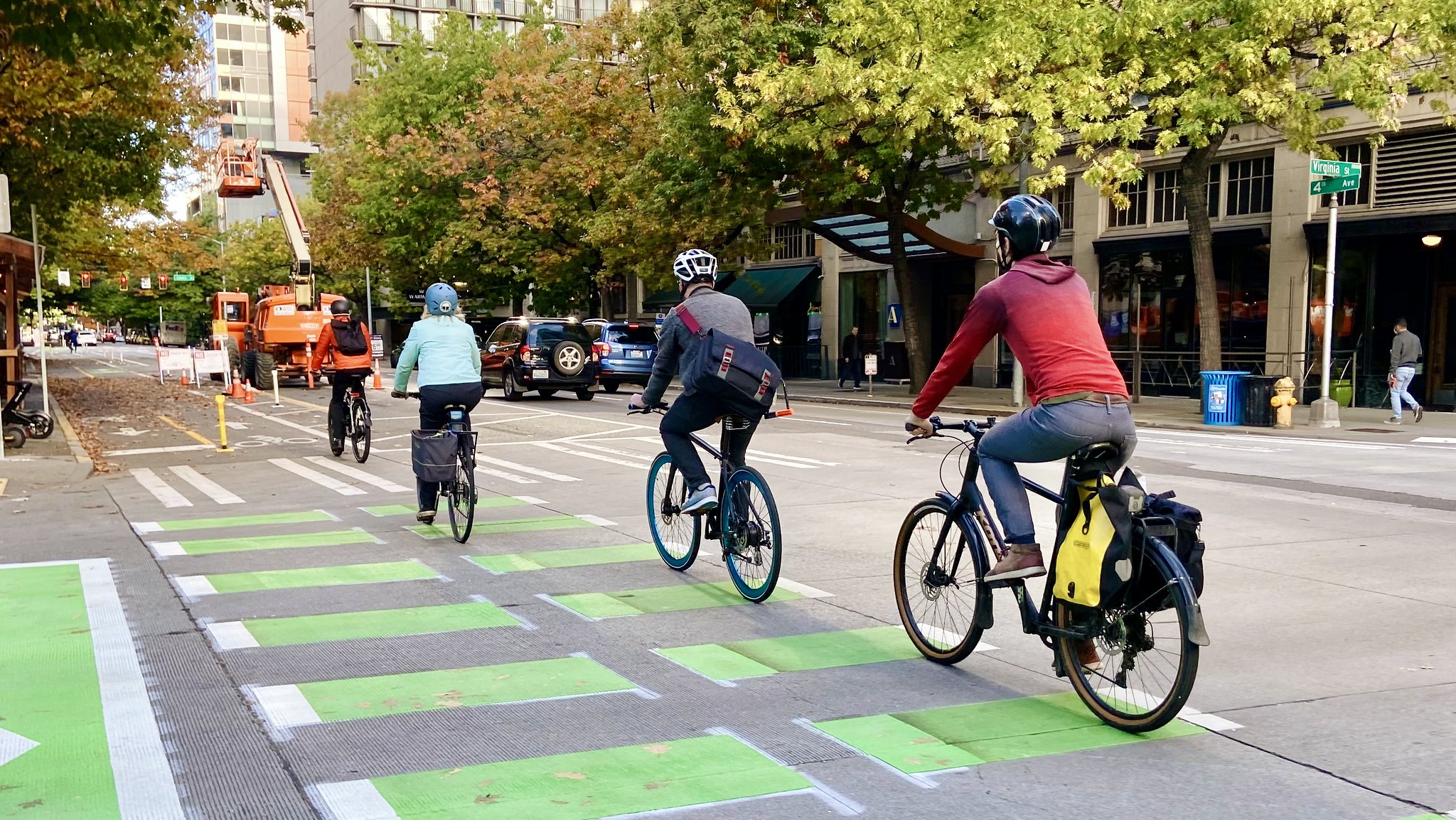 Several cyclists ride through downtown Seattle along the 4th Ave protected bike lane last fall.