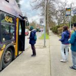 People board a King County Metro bus at a bus stop in southeast Seattle.